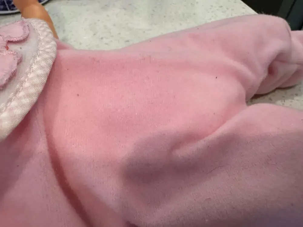 Soft Body Baby Doll with Vinyl Head and Pink Animal Applique Bib